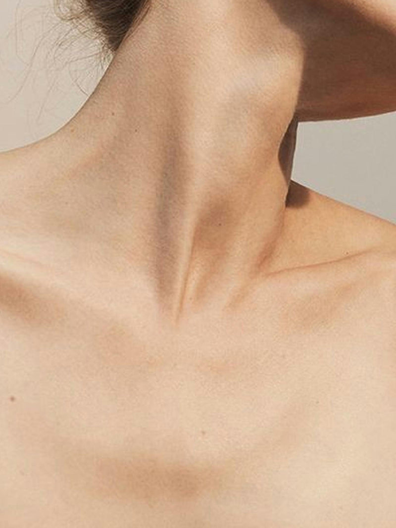Bare neck and collarbone with an even, clear finish and no white cast